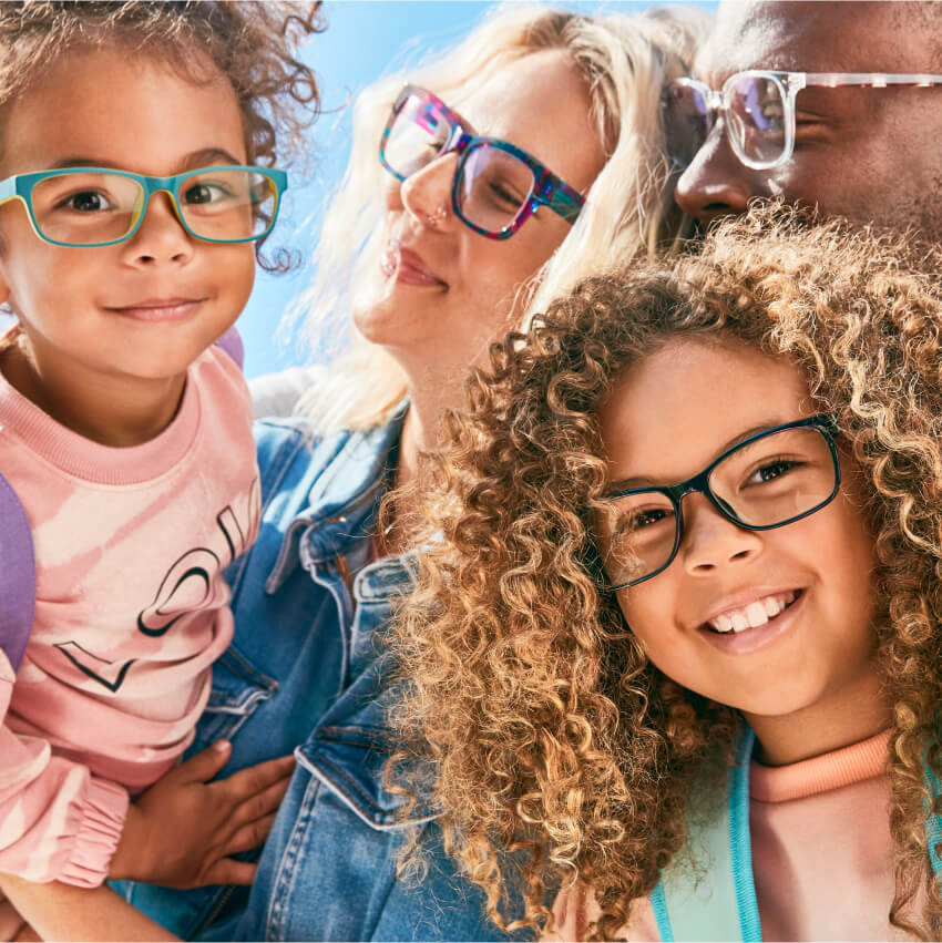 Family wearing colorful glasses, including teal, multi-color, and black frames.