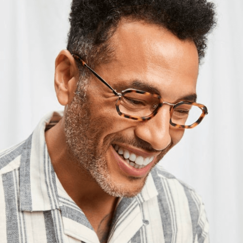 Man wearing tortoiseshell eyeglasses and a striped shirt.