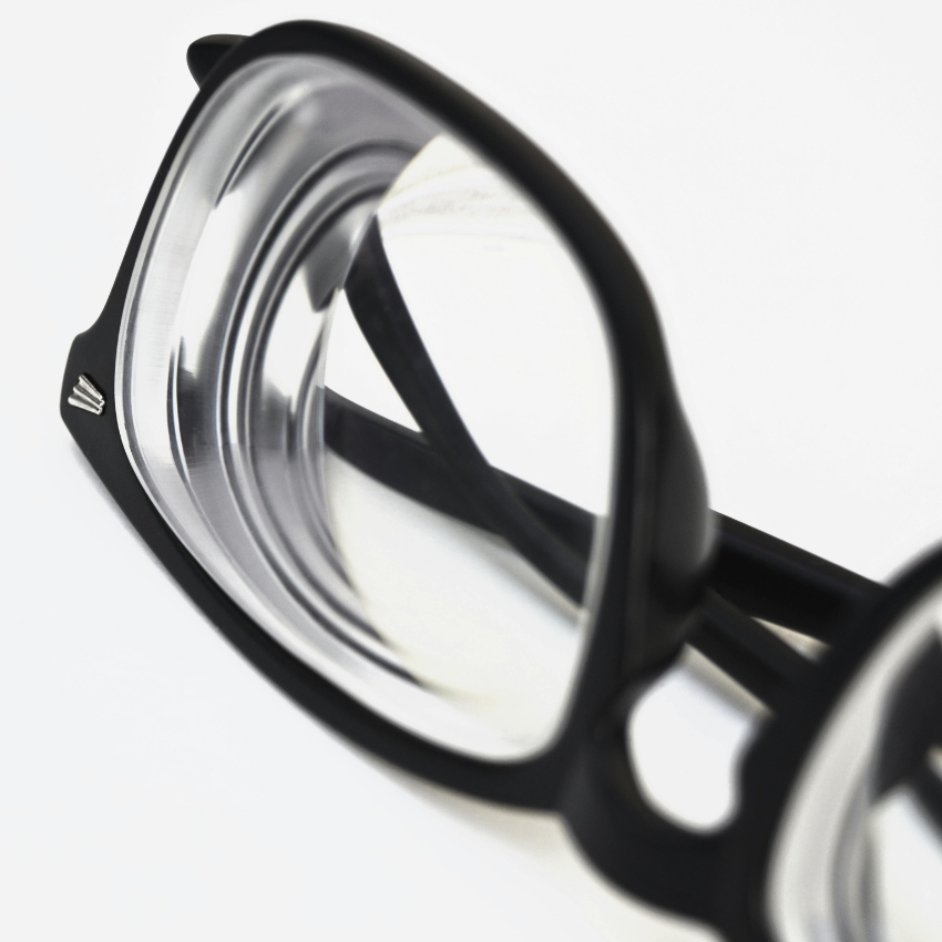 Black-rimmed eyeglasses with clear lenses on a white background.