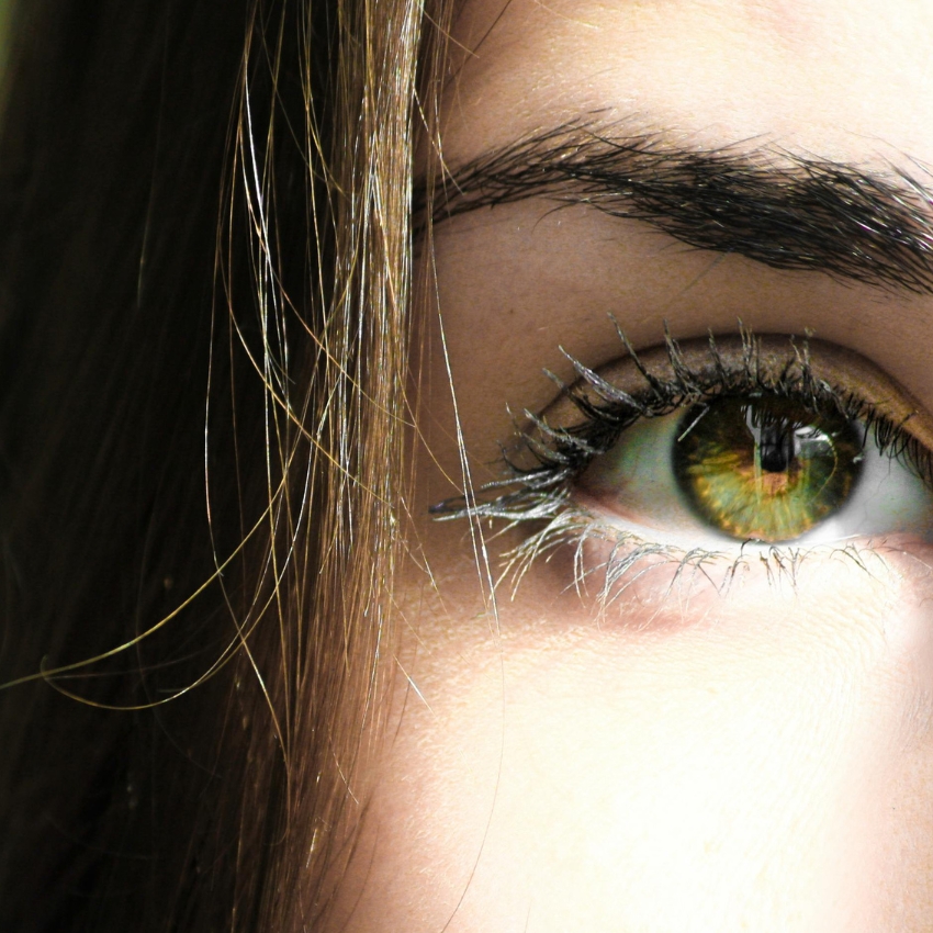 Close-up of a green eye with applied mascara.