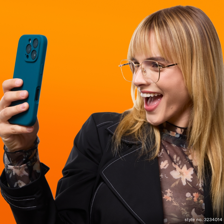 Woman holding teal smartphone case, wearing a floral top and black jacket. Style no. 3234014.